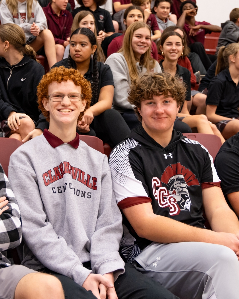 Male students smiling on bleachers