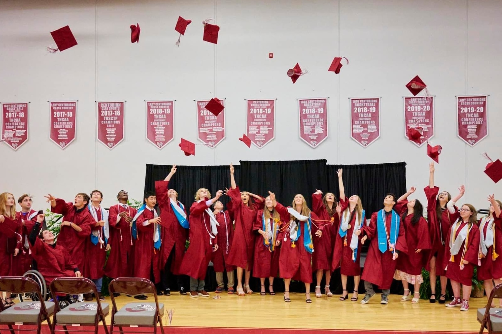 A group of students throw their caps in the air after the graduation ceremony