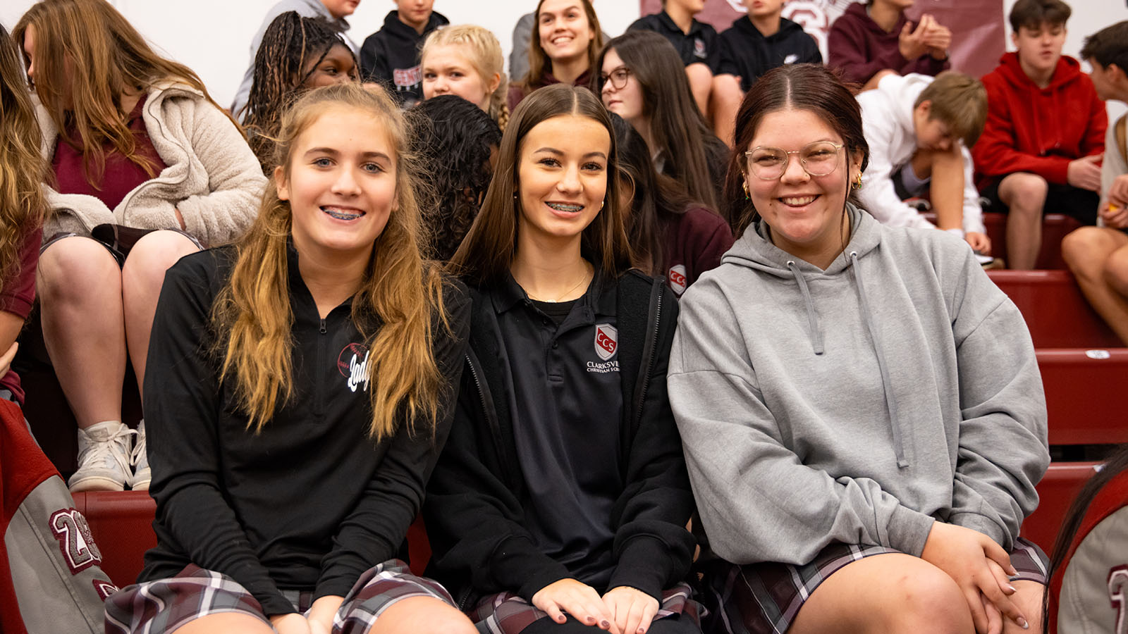 female students smiling on bleachers