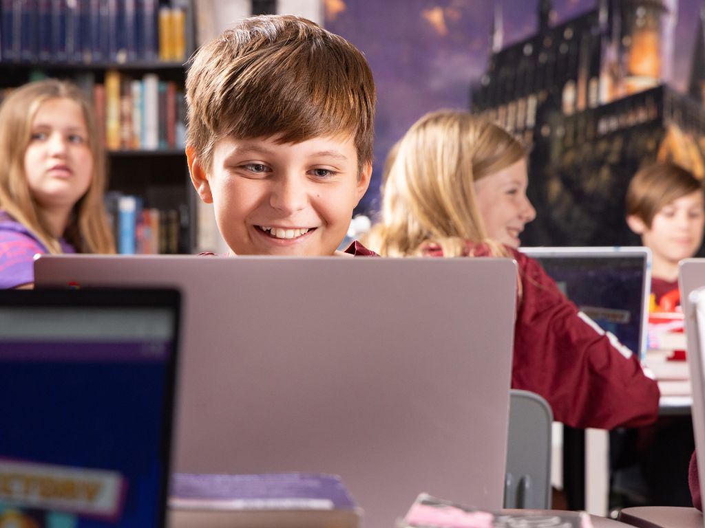 A student works on a laptop in the library
